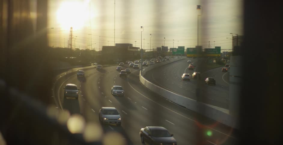 Sun shines onto traffic flowing down controlled access highway