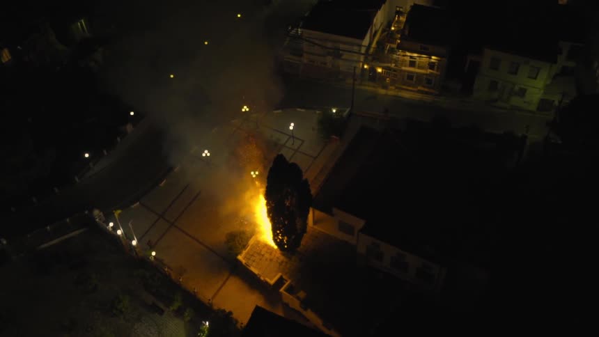 Town with a fire down below that is raging at night