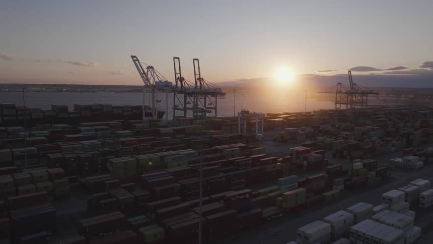 A region with many stacked containers and some huge cranes