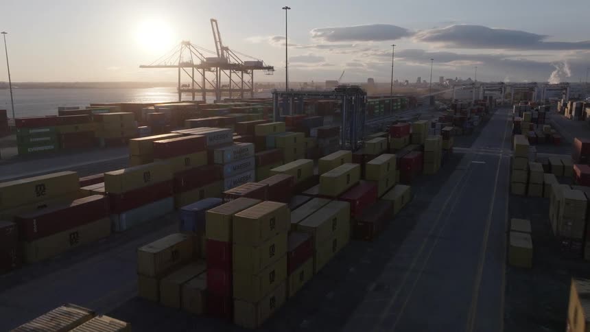 Aerial view of stacked shipping containers at sunset