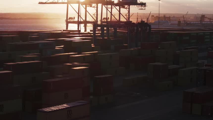 Aerial view of a warehouse filled with shipping containers at sunset