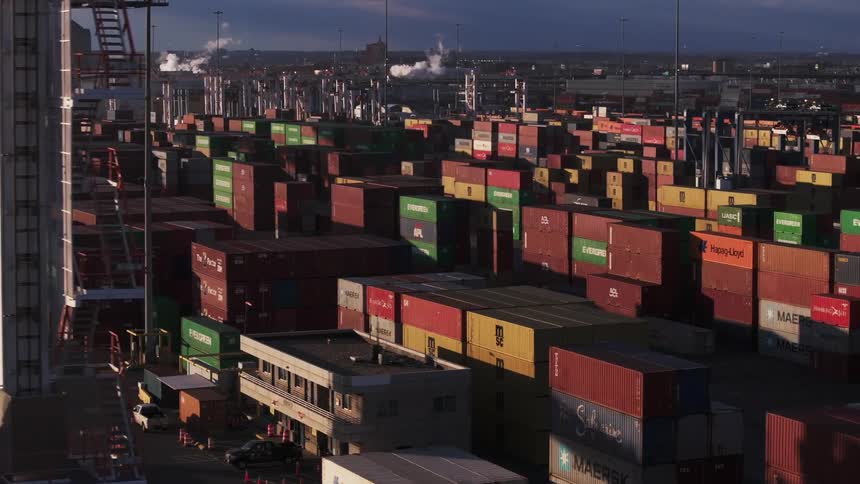 Stacks of shipping containers sitting in a port