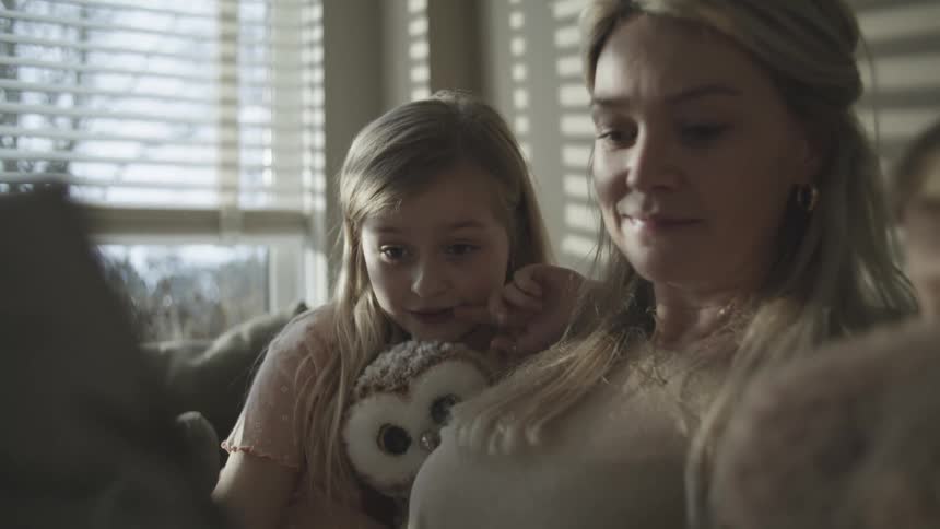 A mother and her children look at something together