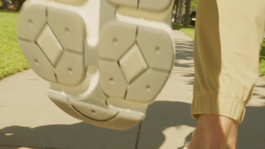 Legs of two people running on the sidewalk of a residential neighborhood