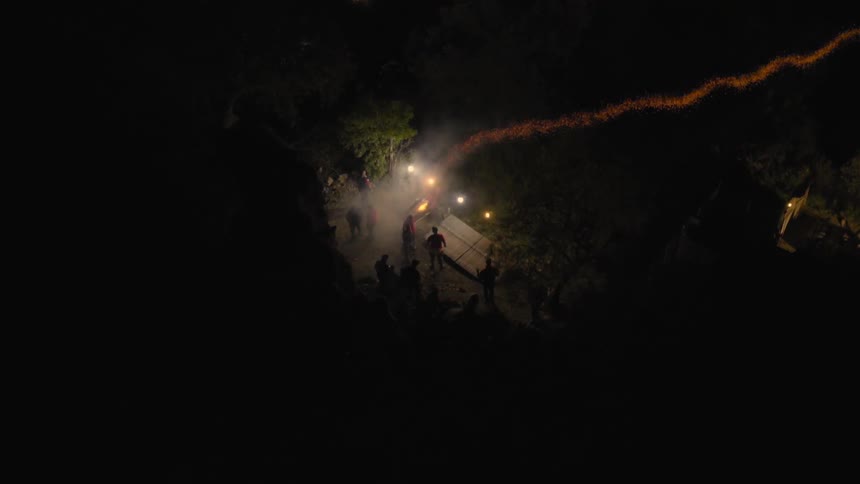 Crowd standing outside lighting off fireworks