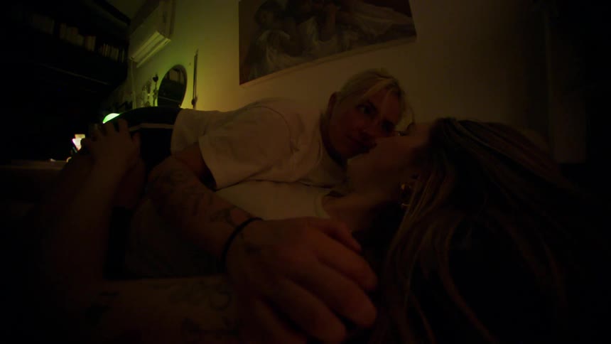 Woman lying on top of her girlfriend stroking her hair in bed