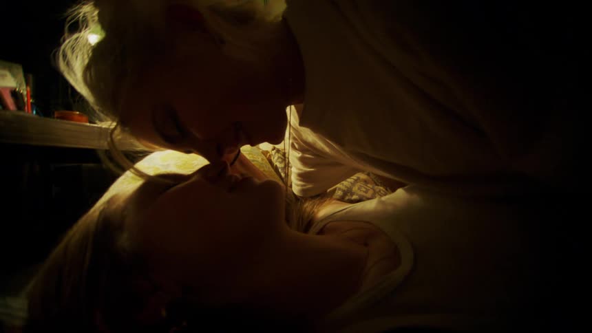 Young couple kissing in the bed on a dimly lit room
