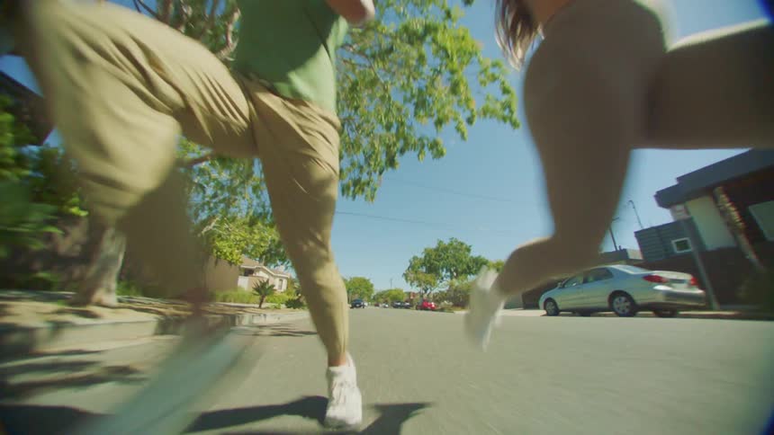 Pair of joggers run in the street in a residential neighborhood