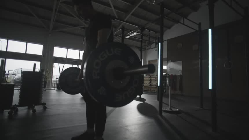 A man in a black shirt is lifting a weight up and down