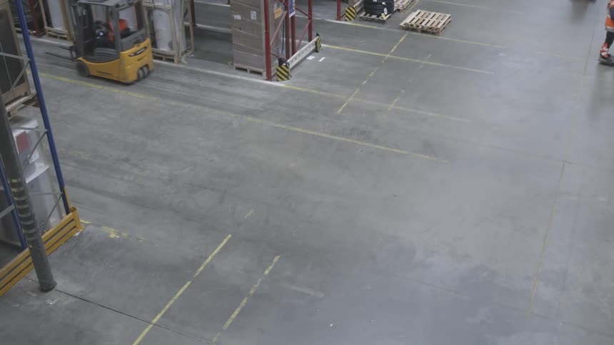 Forklift operators drive vehicles through warehouse