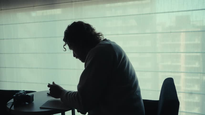 A man writes a note at the table