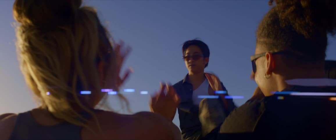 Man with sunglasses dancing standing up for two spectators who are sitting enjoying the vibe on a late afternoon