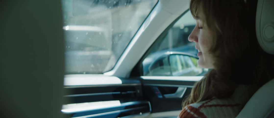 Portrait of a woman in the front seat of a moving car talking