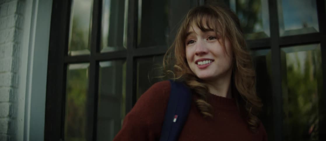 A student waves before entering the school