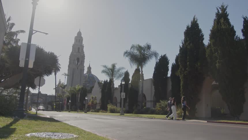 People crossing the street and a cathedral in the background