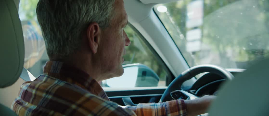 A father chats with his daughter as he drives