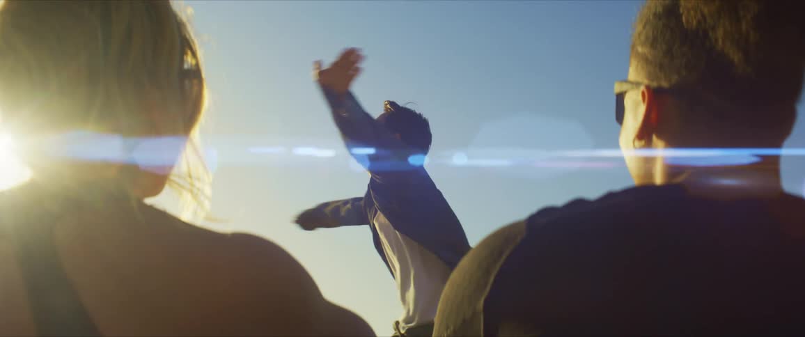 Friends watch him dance under the sun
