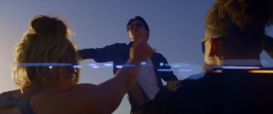 Two friends looking at a man dancing under a blue sky