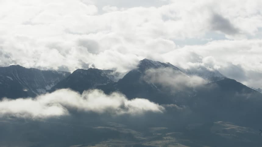 A cloudy mountain range with a peak that peeks through the clouds