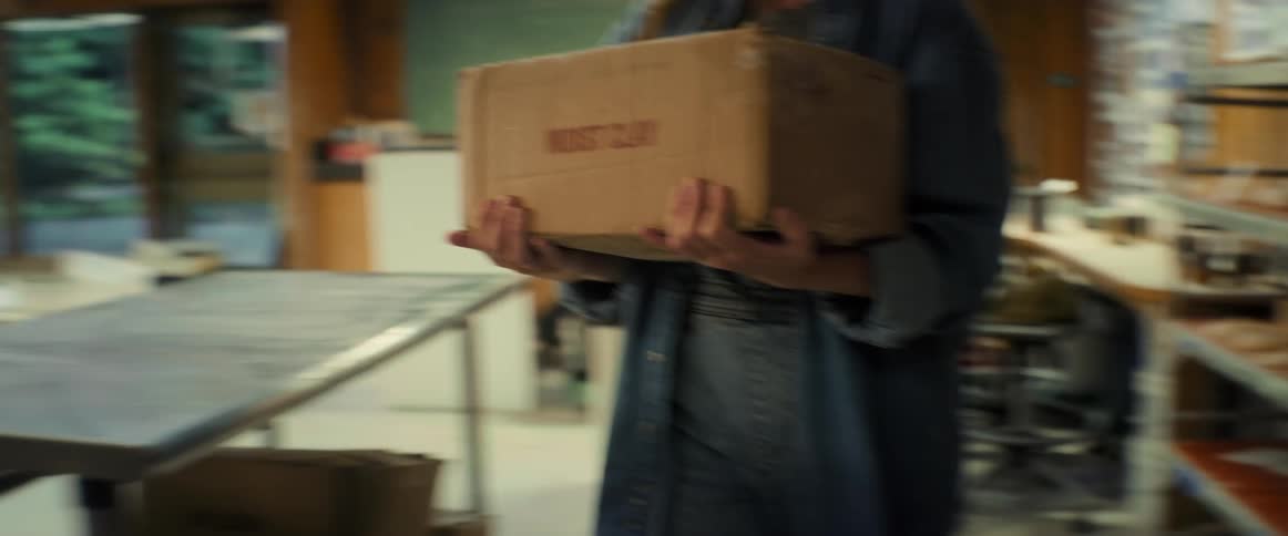 Woman carrying a box inside a workplace