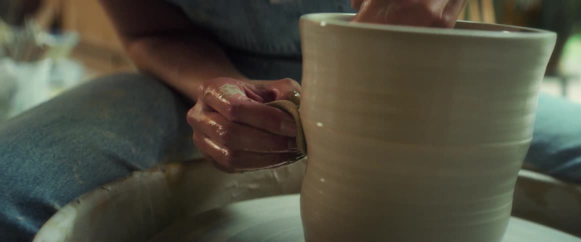 Clay vase being carefully made with a womans hands