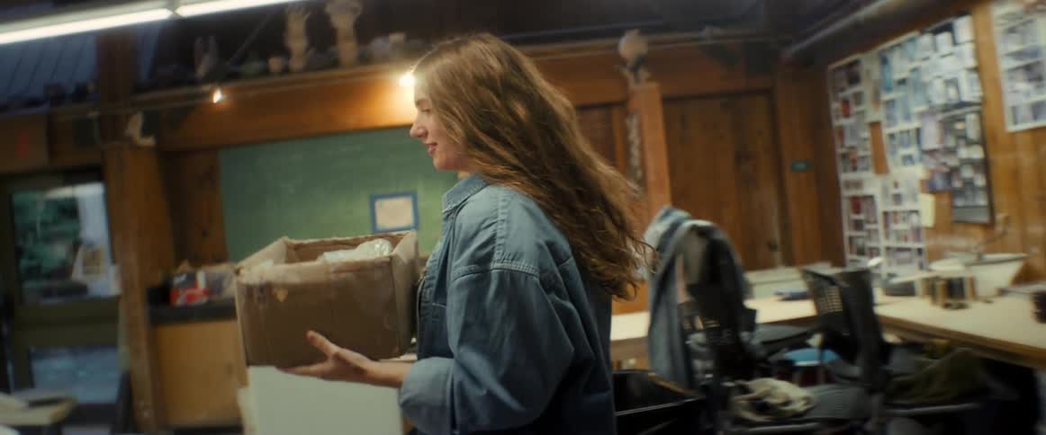 Woman taking a box from a shelf taking it to the table and removing a bag of clay