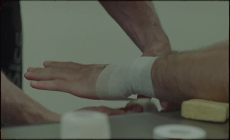A medical professional wraps a mans wrist with a bandage