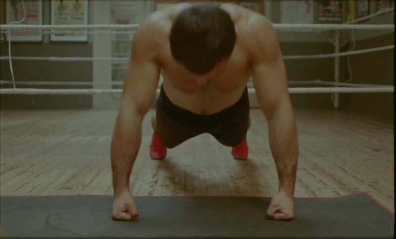 A person performing pushups in a boxing ring