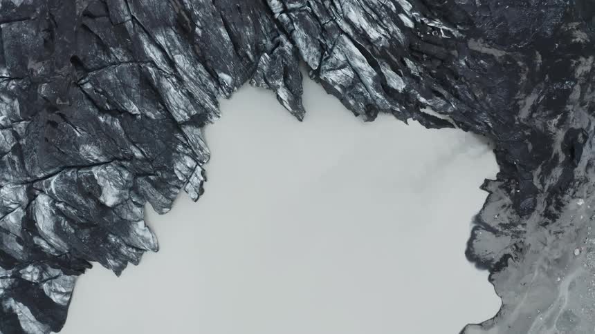 Gray lake with black rocks around it