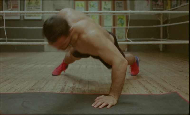 Boxer doing alternate pushups with just one hand