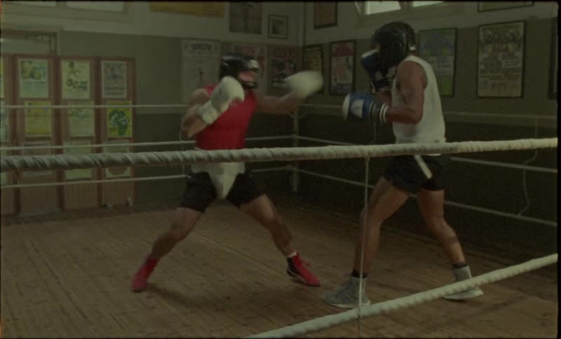 Two boxers fighting while wearing protective head gear