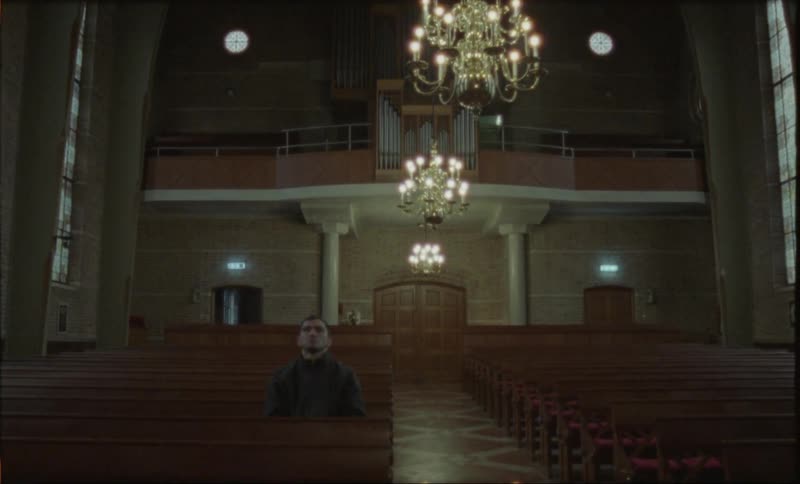 A man sits in a pew in church