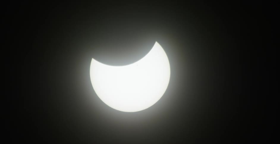 Bright partially eclipsed moon moves slowly through the night sky