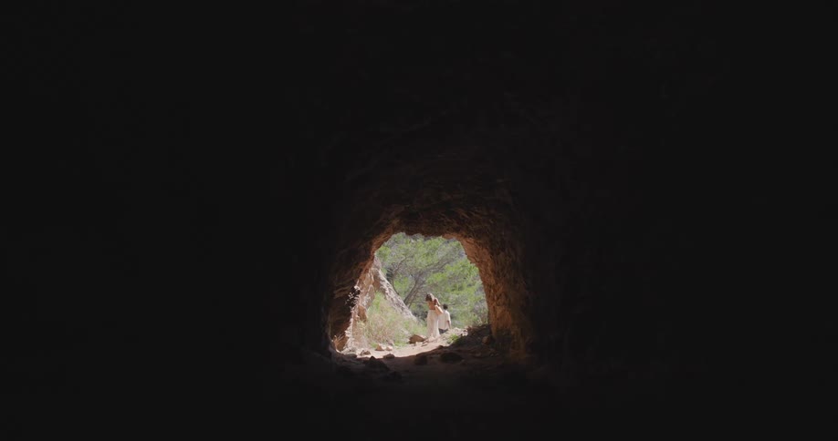 View of a cave and a couple walking in a natural environment