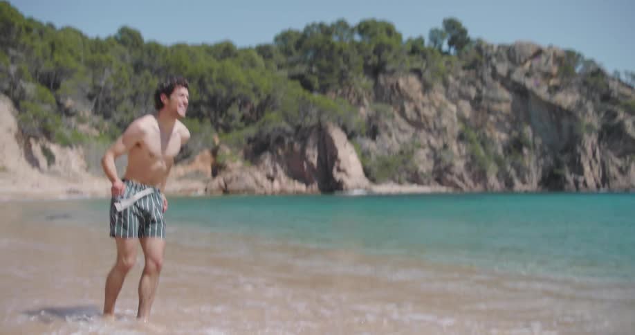 Couple playing splashing water on each other on the beach