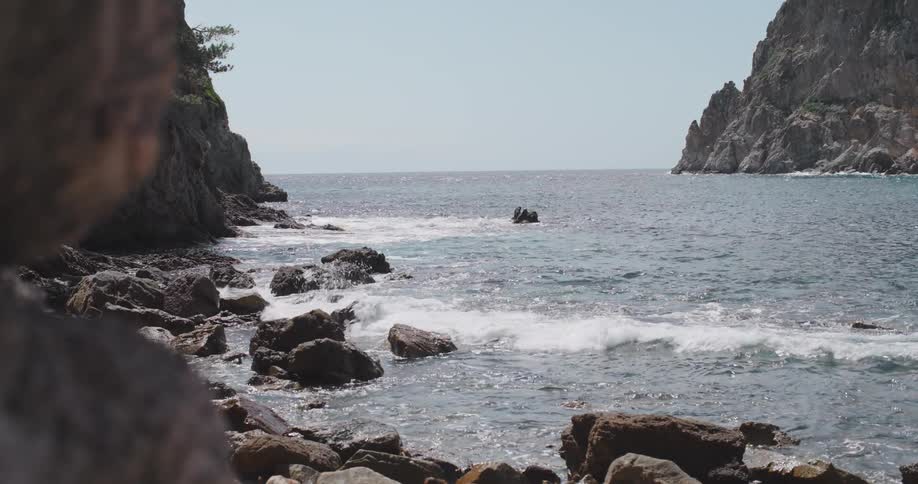 The waves crash against the rugged coastline sending plumes of spray high into the air