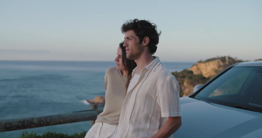 A woman looks longingly at a man next to her at a beach