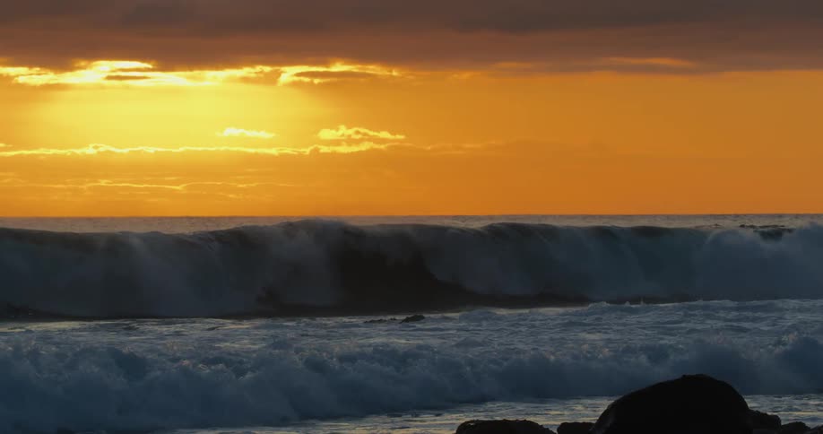 Large waves crash against a beach