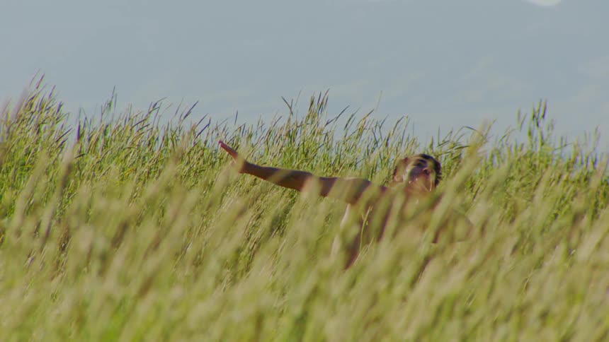 A man is dancing in the tall grass