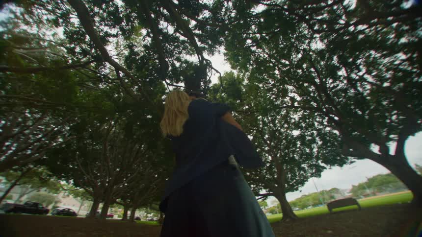Couple of man and woman embracing in a park under trees kissing romantically