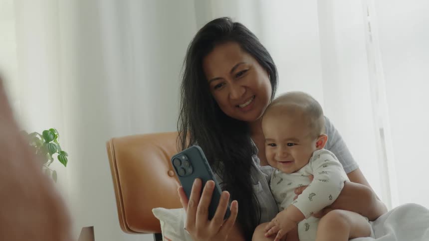 A mother and baby smile at the cell phone