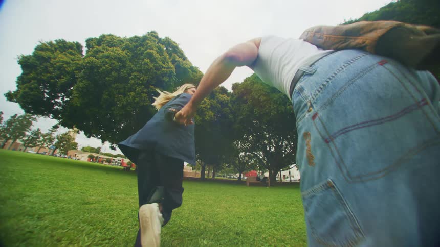 A couple are running through the park
