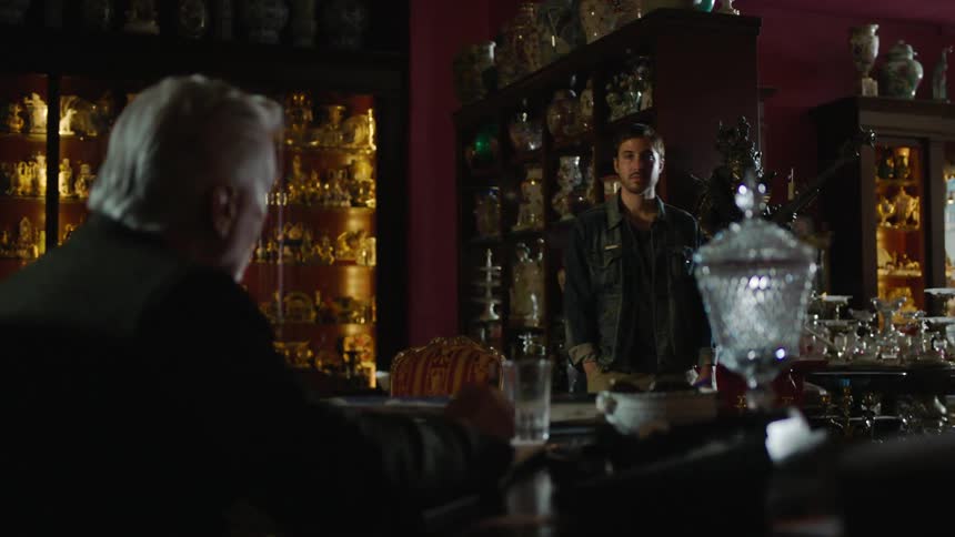 A man is sitting at a desk in a shop