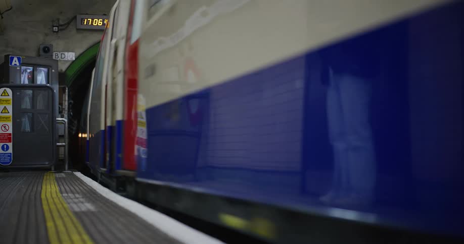 A subway train pulls into an underground station