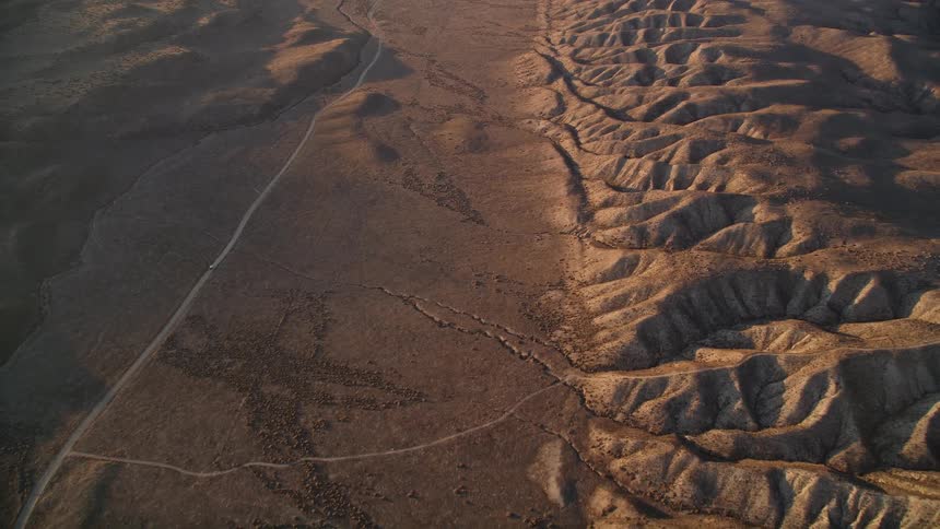 A vehicle drives down the long desert road