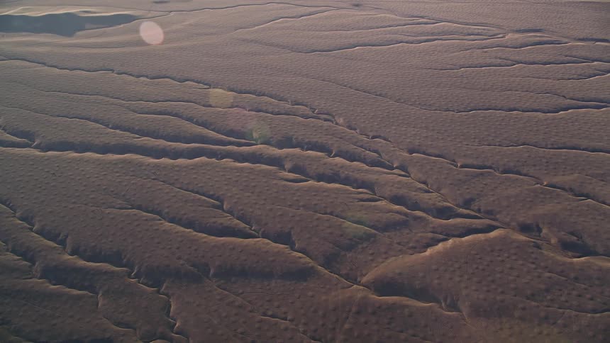 Aerial of large crevices throughout the soil in the desert