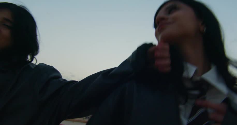 Two friends posing playfully and smiling with a cityscape in the background