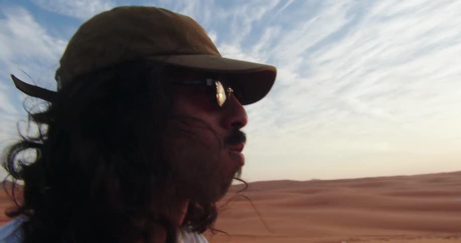 A young man eating candy in te desert at dusk