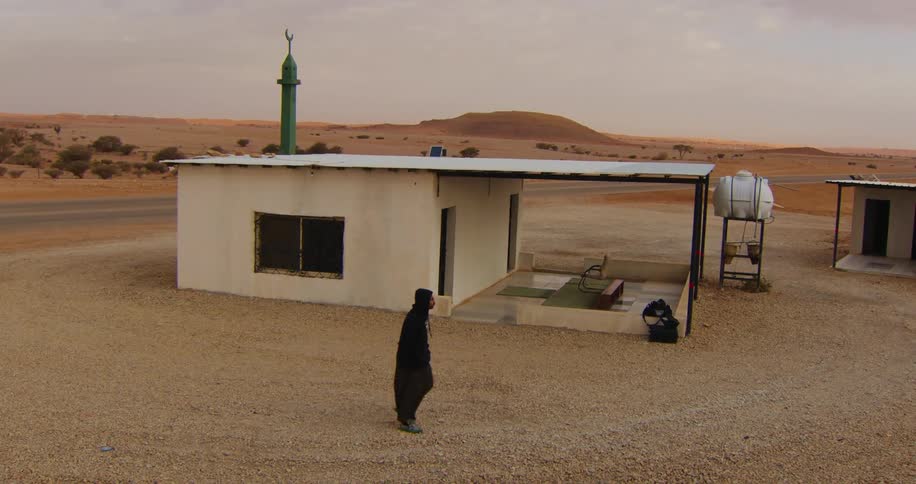 A man walks by the shelter in the desert