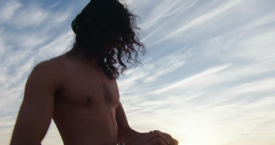 Man changing his shirt while in a natural environment on desert dunes